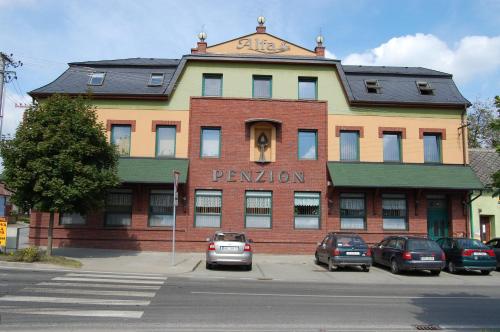 a building on a street with cars parked in front of it at Penzion Alfa in Moravský Písek