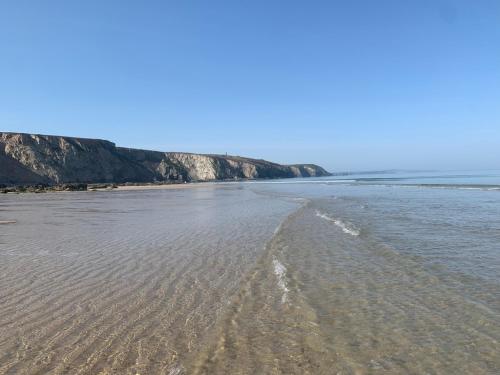 an empty beach with footprints in the sand at Porthtowan Studio in Porthtowan