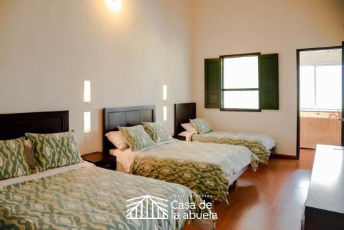 a hotel room with two beds and a window at Hotel Campestre Casa de la Abuela in La Capilla