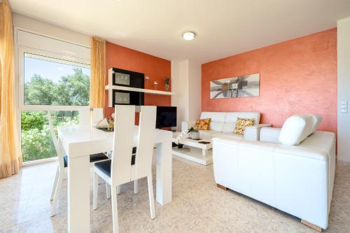 sala de estar con mesa blanca y sofá en Hauzify I Apartament Cala Pepo, en L'Ametlla de Mar