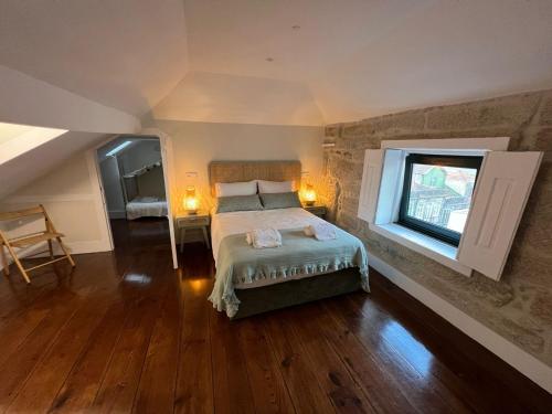 a bedroom with a large bed and a window at A Portuguesa Guest House in Porto