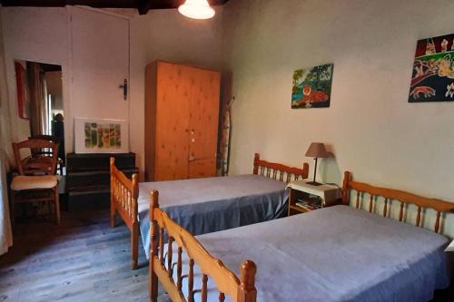 1 Schlafzimmer mit 2 Betten, einem Tisch und Stühlen in der Unterkunft Gîte de charme dans Mas Catalan in Prades