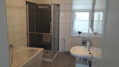 uma casa de banho com uma banheira, um lavatório e um chuveiro em Ferienhaus Renate 7 em Thale