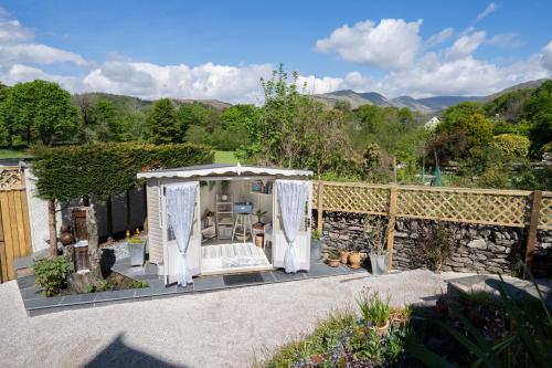 a gazebo with white curtains on a patio at Brantholme Bed & Breakfast in Ambleside