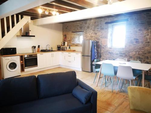 un salon avec un canapé et une table dans une cuisine dans l'établissement Maison Normande proche de la mer et des lieux touristiques, à Quettehou