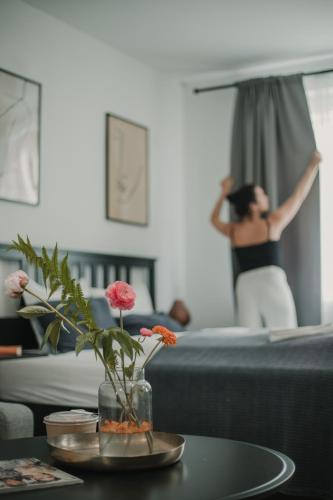 a woman is standing in a living room with a table with flowers at Gallery Apartment 1 in Martin