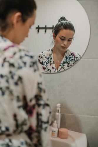a woman looking at her reflection in a mirror at Gallery Apartment 1 in Martin