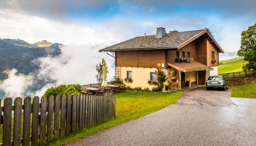 una casa en una colina con un coche aparcado delante en Oberegghof, en Wagrain
