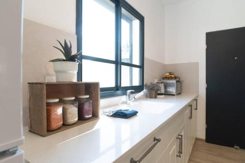 a kitchen with a counter with a sink and a window at אצל אהרונ'ק Aronek's Place in ‘Amir