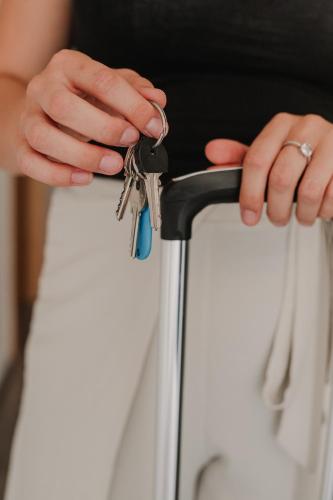 a woman holding a bunch of keys on a suitcase at Gallery Apartment 1 in Martin