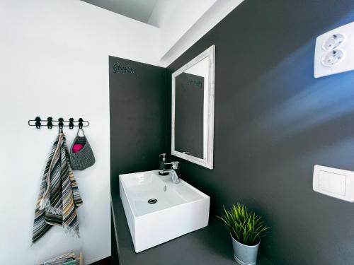 La salle de bains est pourvue d'un lavabo blanc et d'un miroir. dans l'établissement Glamping Langus, à Topolšica