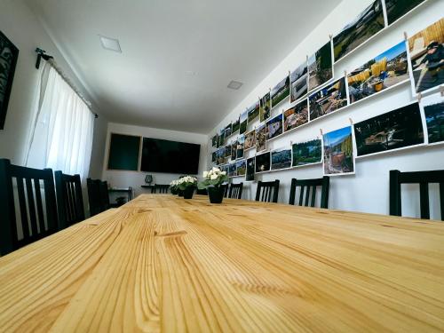 a long wooden table in a room with pictures on the wall at Glamping Langus in Topolšica