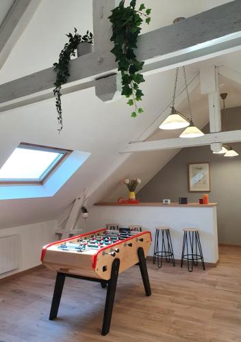 Cette chambre mansardée dispose d'une table. dans l'établissement Le Clos de Baron sur Odon, un havre de paix., à Baron-sur-Odon