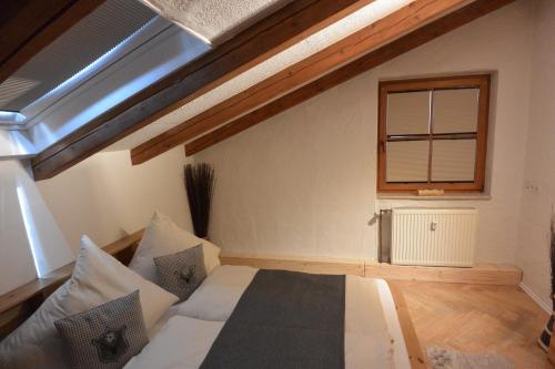 a bedroom with a bed with pillows and a window at Alpenchalet Karwendel in Mittenwald