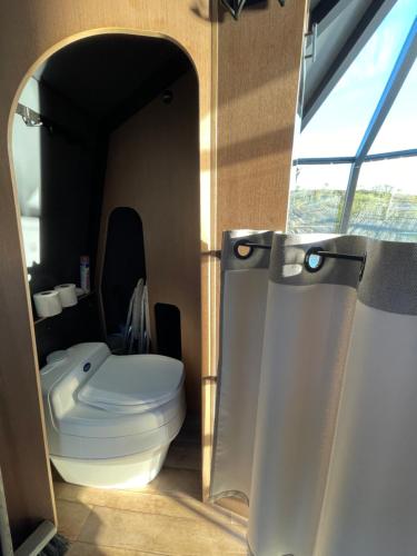 a bathroom with a white toilet and a mirror at Aurora Hut - luksusmajoitus iglu tunturilammella Pohjois-Lapissa Nuorgamissa in Nuorgam