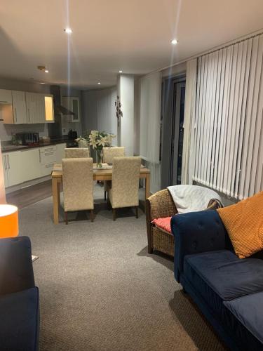 a living room with a couch and a table with chairs at City Centre Penthouse Apartment in Sunderland