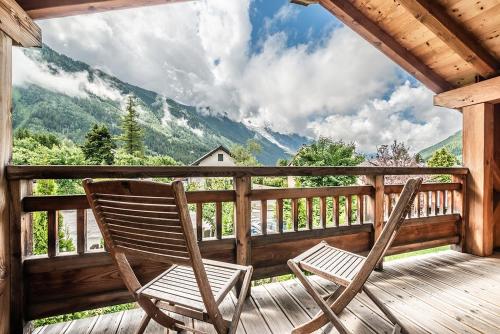 two chairs sitting on a porch with a view of mountains at Eden Hotel, Apartments and Chalet Chamonix Les Praz in Chamonix-Mont-Blanc