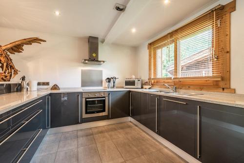 a kitchen with stainless steel appliances and a window at Eden Hotel, Apartments and Chalet Chamonix Les Praz in Chamonix-Mont-Blanc