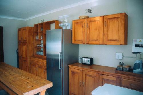 GravelotteにあるMazunga Tented Campのキッチン(木製キャビネット、ステンレス製の冷蔵庫付)
