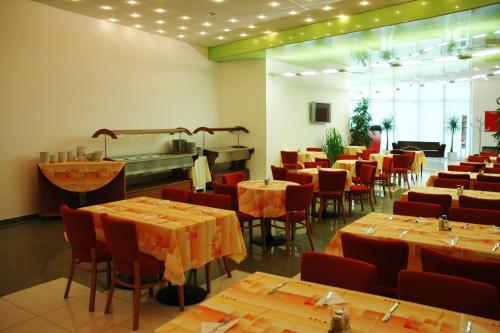 a dining room with tables and chairs and a restaurant at Olympik Artemis in Prague