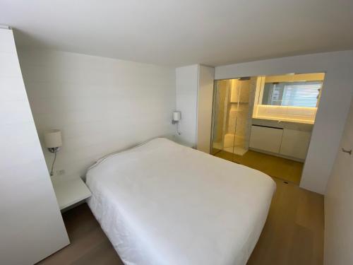 une chambre avec un lit blanc et une fenêtre dans l'établissement Dunes and Sea, à Nieuport