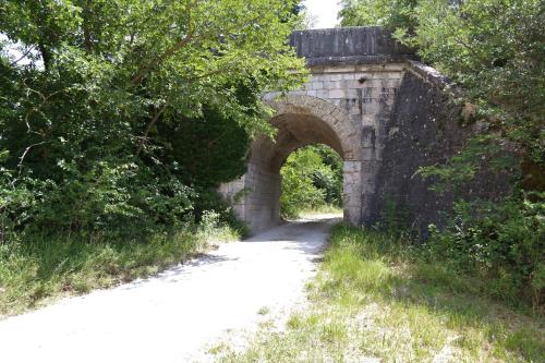 an old stone bridge with an arch over a dirt road at Casa La Gorga in Cagli