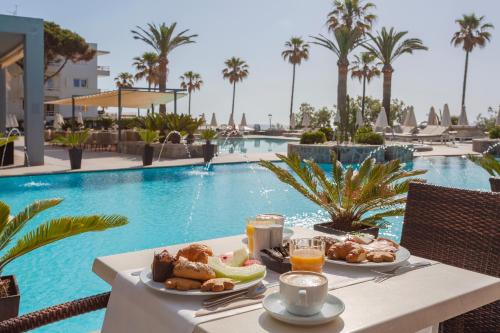 stolik ze śniadaniem przy basenie w obiekcie Marins Suites - Adults Only Hotel w Cala Millor