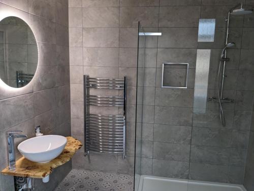 a bathroom with a shower and a sink and a tub at Alexander Lodge Guest House in Bournemouth