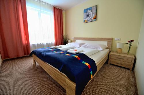 Banka的住宿－Hotel KOREKT，一间卧室配有一张带蓝色毯子的床