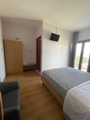 a bedroom with a bed and a tv on the wall at Αφροδίτη Hotel in Néon Rýsion