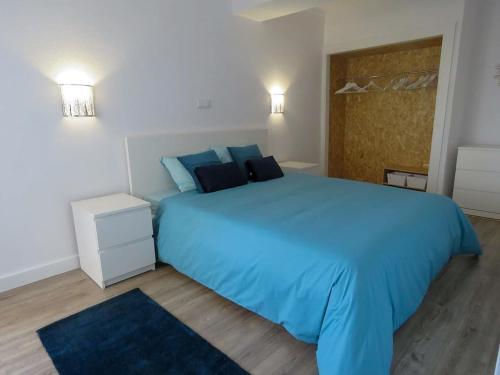sypialnia z dużym niebieskim łóżkiem z niebieskimi poduszkami w obiekcie Rocha SPOT w mieście Portimão