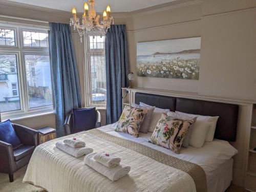 Alexander Lodge Guest House في بورنموث: غرفة نوم عليها سرير وفوط