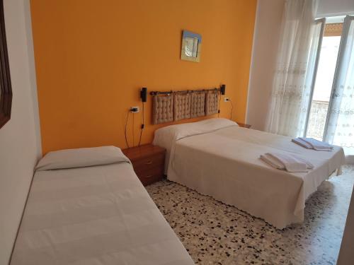 a bedroom with two beds and a window at Albergo Nella in Imperia