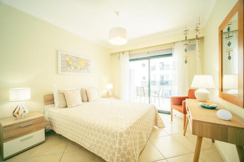 um quarto com uma cama, uma cadeira e uma janela em Albufeira - Cerro Mar Star - Cozy and Relaxing T1 em Albufeira