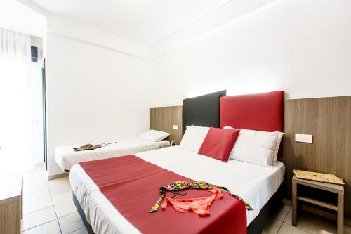 a hotel room with two beds with a red headboard at Hotel Grazia Riccione in Riccione