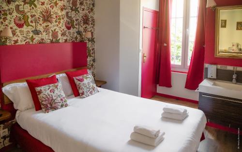 a bedroom with a large white bed with red walls at Hotel de Charme La Bonne Adresse - Logis hotels in Le Havre