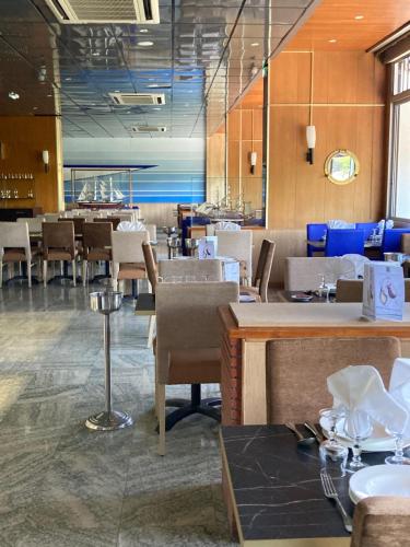 een eetkamer met tafels en stoelen in een restaurant bij Hôtel Christina Lourdes in Lourdes