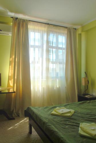 a bedroom with a green bed and a window at Curtea Brancovenească in Constanţa