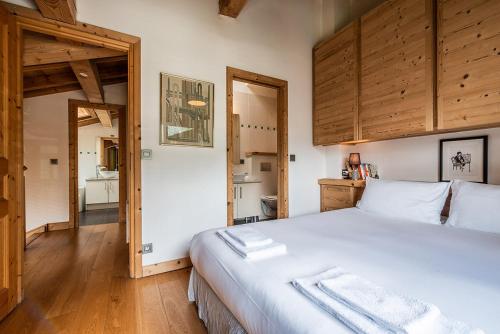 a bedroom with a large white bed with wooden cabinets at Eden Hotel, Apartments and Chalet Chamonix Les Praz in Chamonix-Mont-Blanc