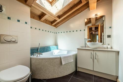 a bathroom with a tub and a sink and a toilet at Eden Hotel, Apartments and Chalet Chamonix Les Praz in Chamonix-Mont-Blanc