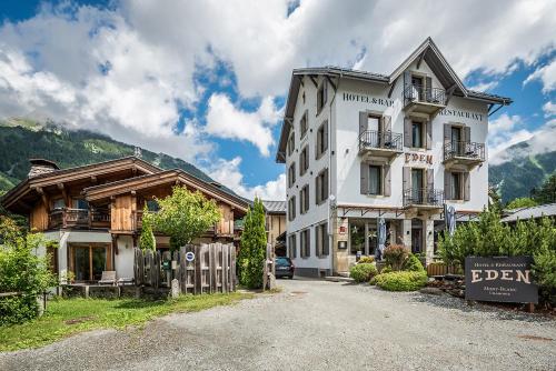 a large white building with a sign in front of it at Eden Hotel, Apartments and Chalet Chamonix Les Praz in Chamonix-Mont-Blanc