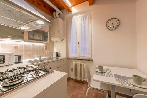 a kitchen with a stove and a clock on the wall at VIA 5 GIORNATE 13 - Apartment in Como