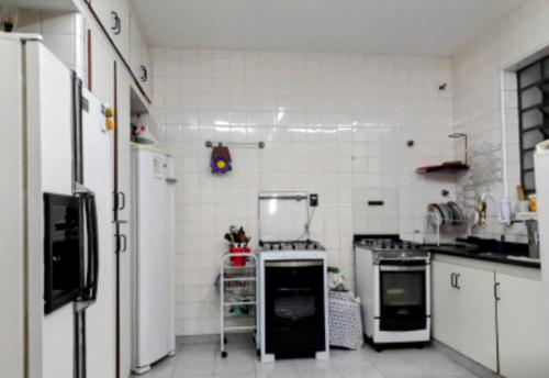 uma cozinha com paredes brancas e electrodomésticos brancos em Casa Nova em São Paulo