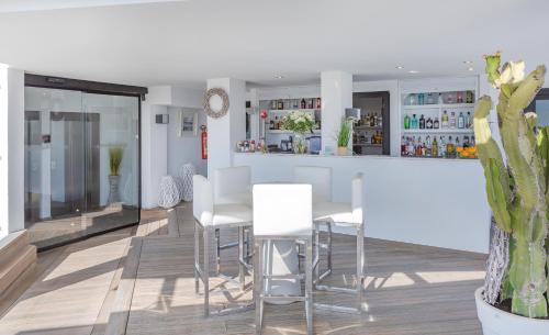 a dining room with white tables and white chairs at Marins Playa in Cala Millor