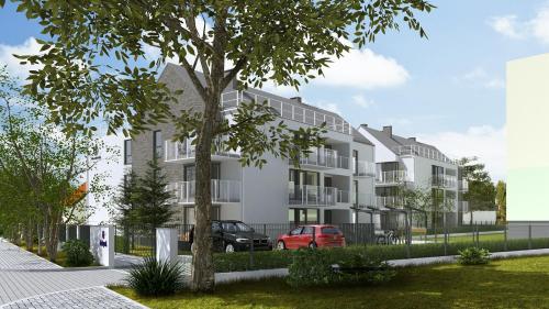 duży biały budynek z drzewem przed nim w obiekcie Villa Neptun - apartament przyjazny zwierzętom w Gdańsku