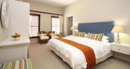 a bedroom with a large bed with a blue headboard at Lavender Manor Guest Lodge in Hermanus
