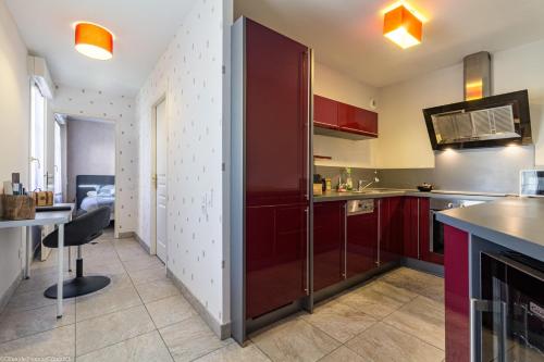 une cuisine avec des placards rouges et une salle à manger dans l'établissement Résidence Egalité - Montmartre, à Dijon