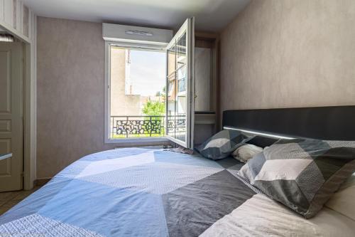 Un dormitorio con una cama grande y una ventana. en Résidence Egalité - Montmartre, en Dijon