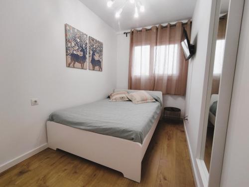 a small bedroom with a bed and a window at Apartamento Santander Maliaño in Maliaño