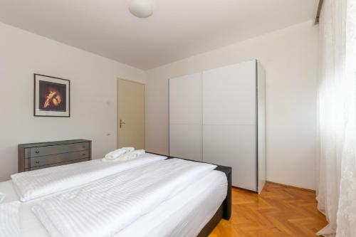 - une chambre avec 2 lits blancs et une fenêtre dans l'établissement Apartment Omiška, à Split
